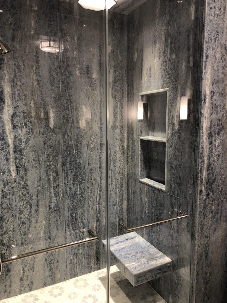 Bathroom shower in blue quartz slab with custom mosaic floor
