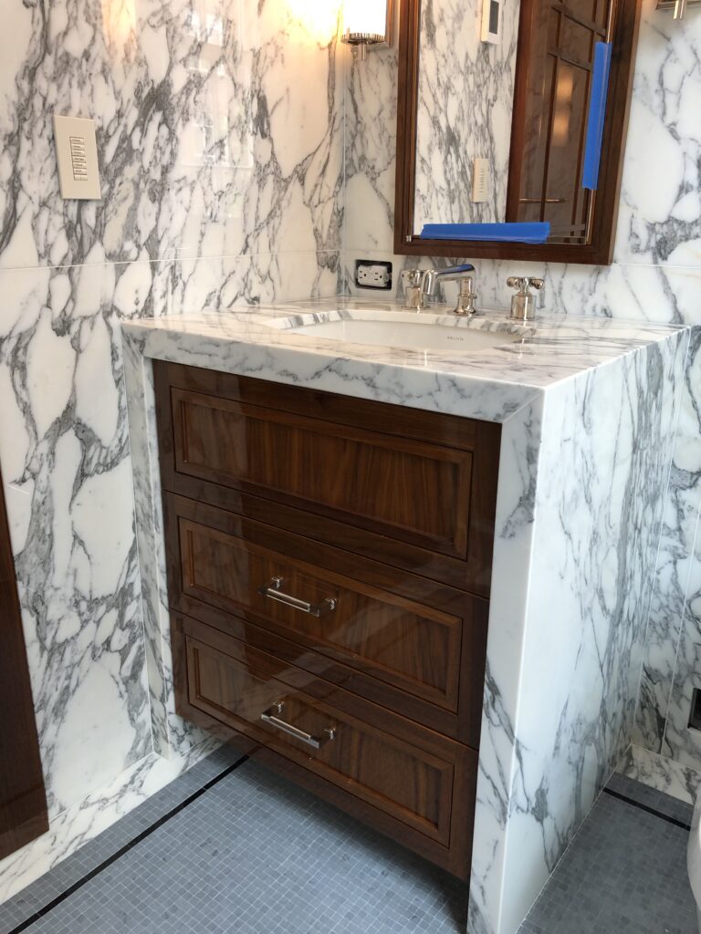 His bathroom vanity and walls in arabescato calacatta marble