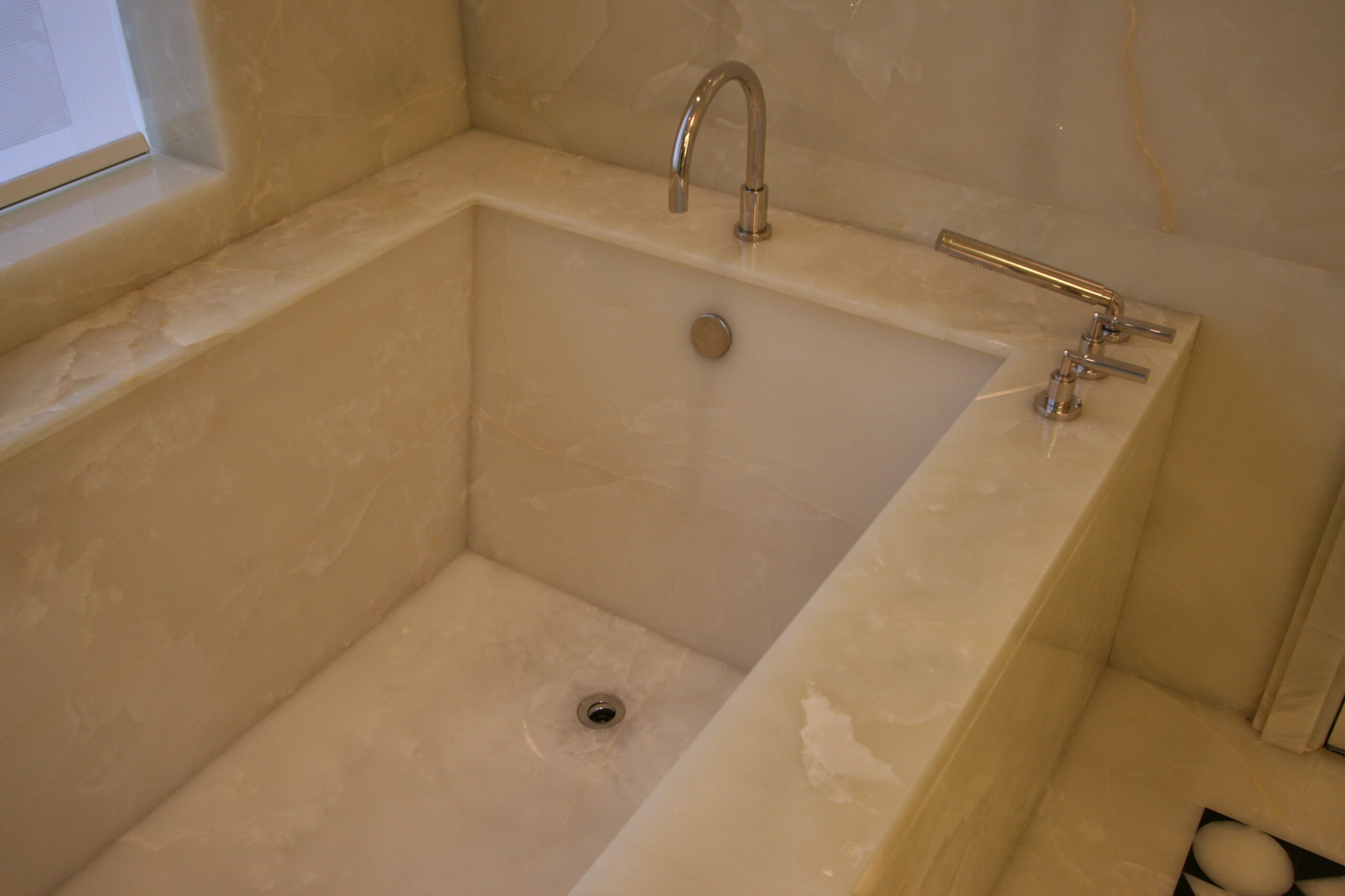 Master bathroom bathtub in white onyx slab